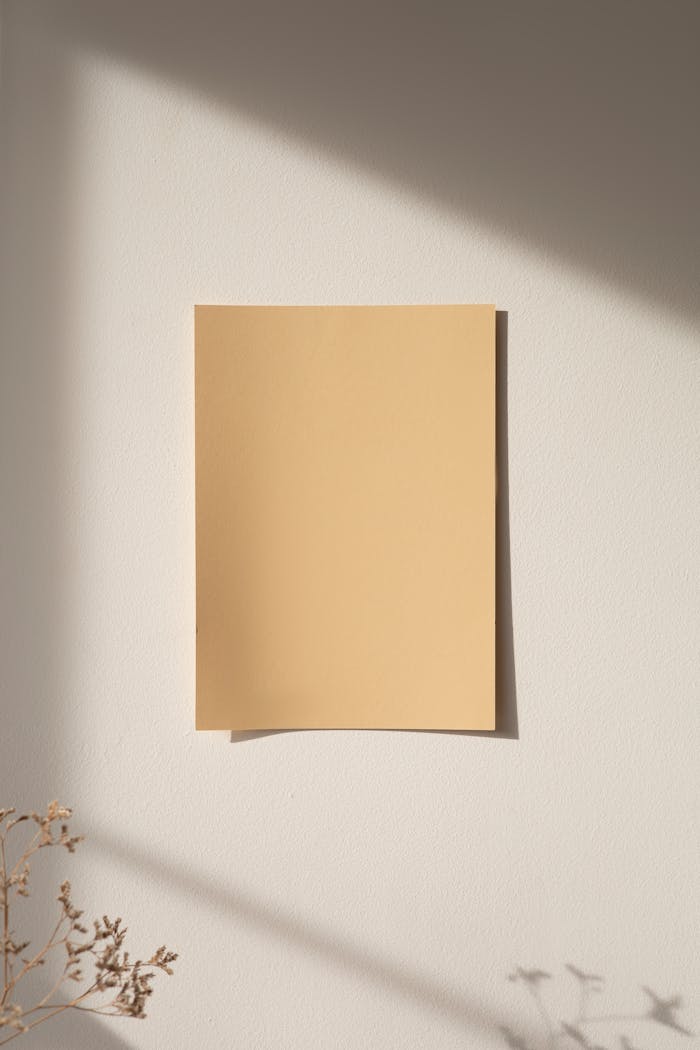 about-us A minimalist mockup of beige paper on a sunlit wall, perfect for design presentations.